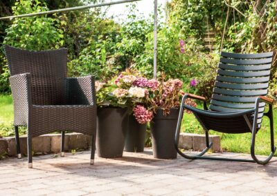 Terrasse med blomster og havemøbler ved HabitusHuset Kobberøvej.