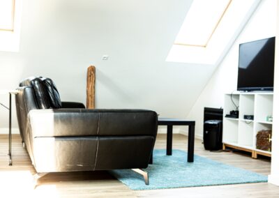 Sort sofa i stueområde med ovenlys på HabitusHuset Kobberøvej.